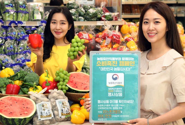 이마트 성수점 농산 매장에서 모델들이 농산물 할인 행사를 소개하고 있다. 사진=이마트 제공