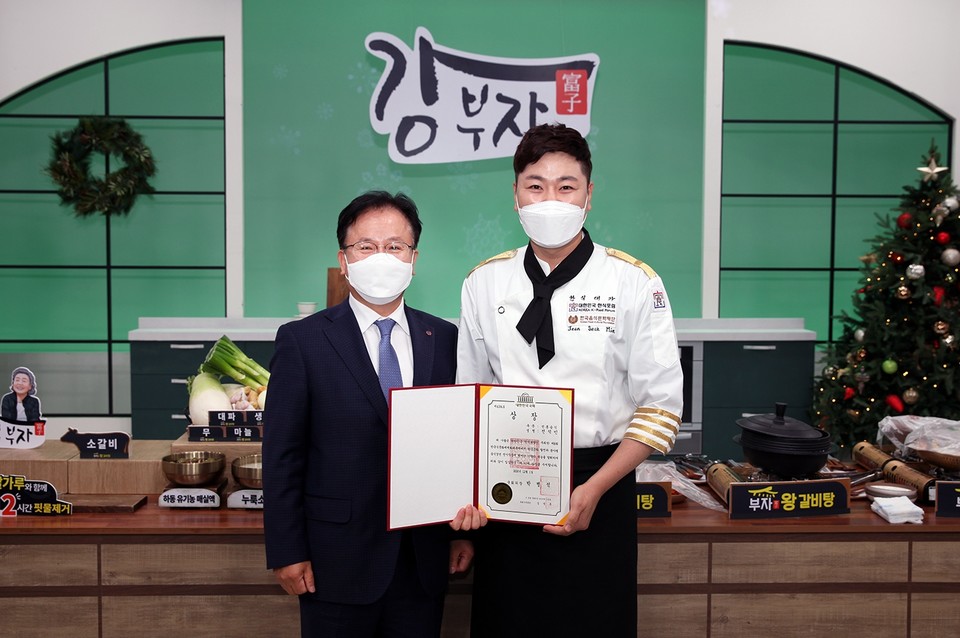 제8회 한국식문화 세계화 대축제에서 국회의장상을 수상한 전석민 쇼핑호스트(오른쪽)가 축하하기 위해 스튜디오를 방문한 NS홈쇼핑 조항목 공동대표이사와 기념사진을 촬영하고 있다. 사진=NS홈쇼핑 제공