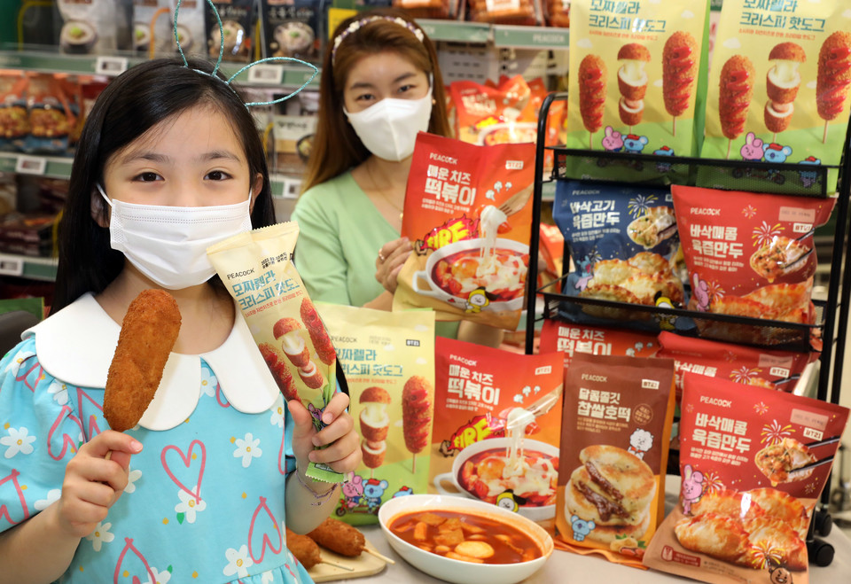 이마트 성수점에서 모델들이 '피코크 BT21' 서울의 맛 분식 7종 상품을 소개하고 있다. 사진=이마트