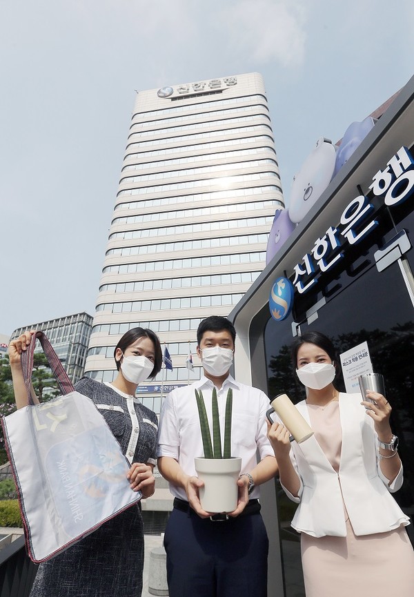 신한은행 직원들이 12일 서울 중구 본점에서 사용했던 각종 폐현수막을 재활용한 장바구니와 공기정화식물인 스투키, 대표적 다회용기인 텀블러를 들고 '신한 ESG 실천 빌딩' 선언에 동참하고 있다. 사진=신한은행