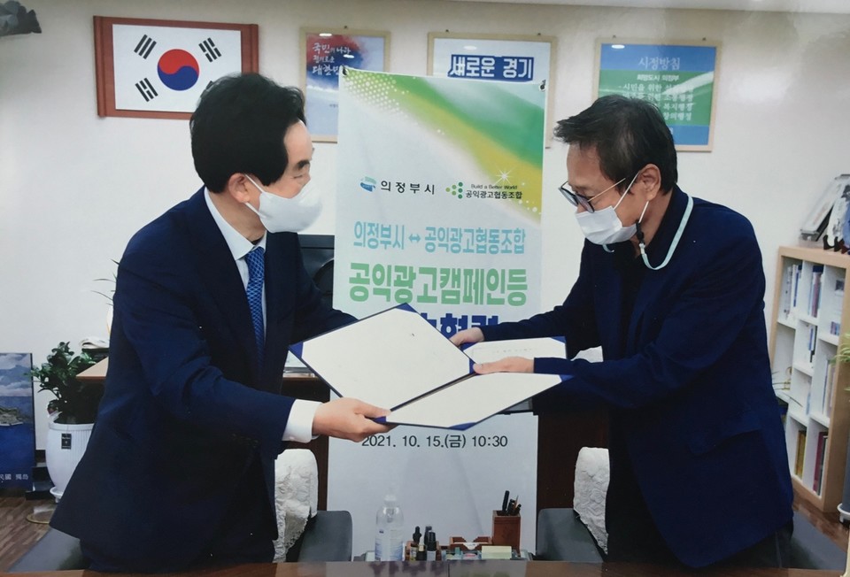 공익광고 사회적 협동조합 이주용 이사장(오른쪽)과 안병용 의정부시장이 상호 협력을 위한 업무협약식에서 협약서를 잔딜하고 있다. 사진=공익광고 사회적 협동조합