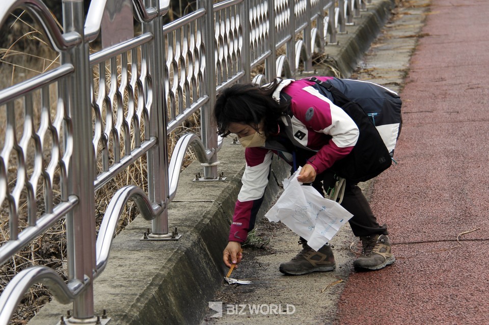 구이저수지 트랭킹 중 참가자가 버려진 쓰레기를 줍고 있다. 사진=손진석 기자