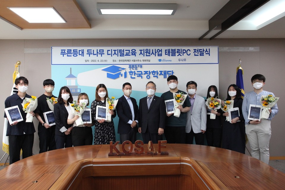 이석우(왼쪽 여섯 번째) 두나무 대표와 정대화(일곱 번째) 한국장학재단 이사장, 장학생들이 '푸른등대 두나무 디지털교육 지원사업 태블릿PC 전달식'에서 기념촬영을 하고 있다. 사진=두나무