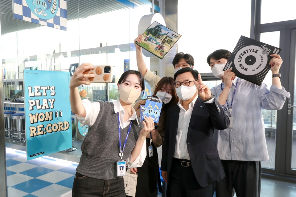 이원덕 우리은행장(앞줄 오른쪽)이 서울 마포구 우리은행X무신사 혁신점포 '원 레코드(WON RE:CORD)'에 방문해 점포를 기획한 직원들과 함께 기념 촬영을 하고 있다. 사진=우리은행
