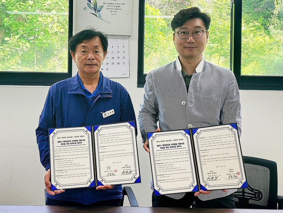 박준범 제천시 관광사업단 단장(오른쪽)과 오영록 청풍호반 케이블카 대표가 업무협약을 진행하고 기념사진을 촬영하고 있다. 사진=제천시 계획공모 관광사업단