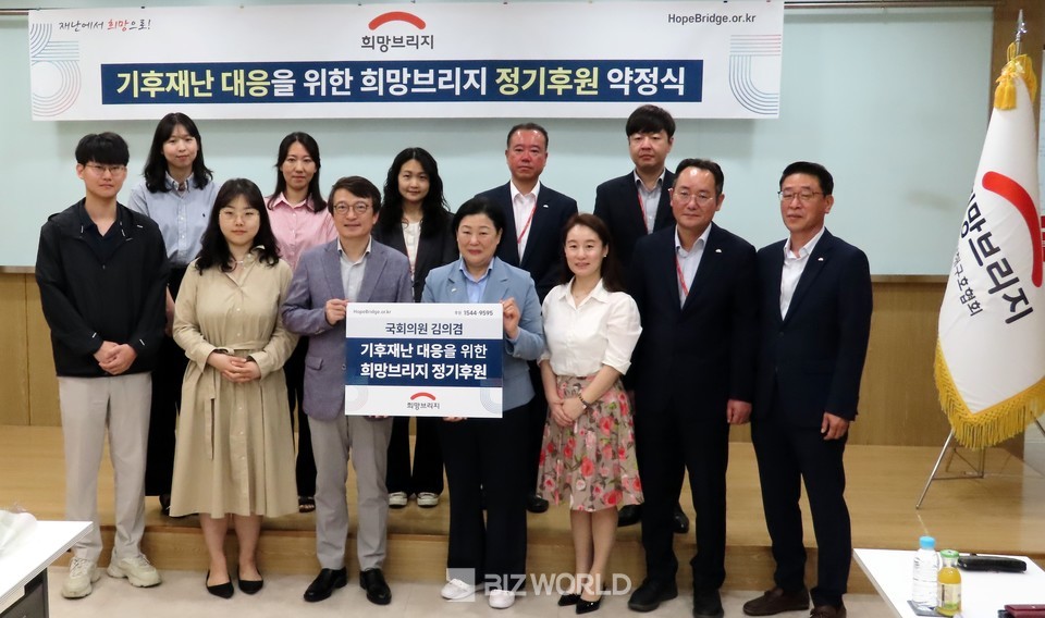 김의겸 의원(왼쪽 세번째)와 김정희 사무총장(왼쪽 네번째)이 기후재난 대응을 위한 희망브리지 정기후원 약정식을 가지고 기념사진을 촬영하고 있다. 사진=손진석 기자