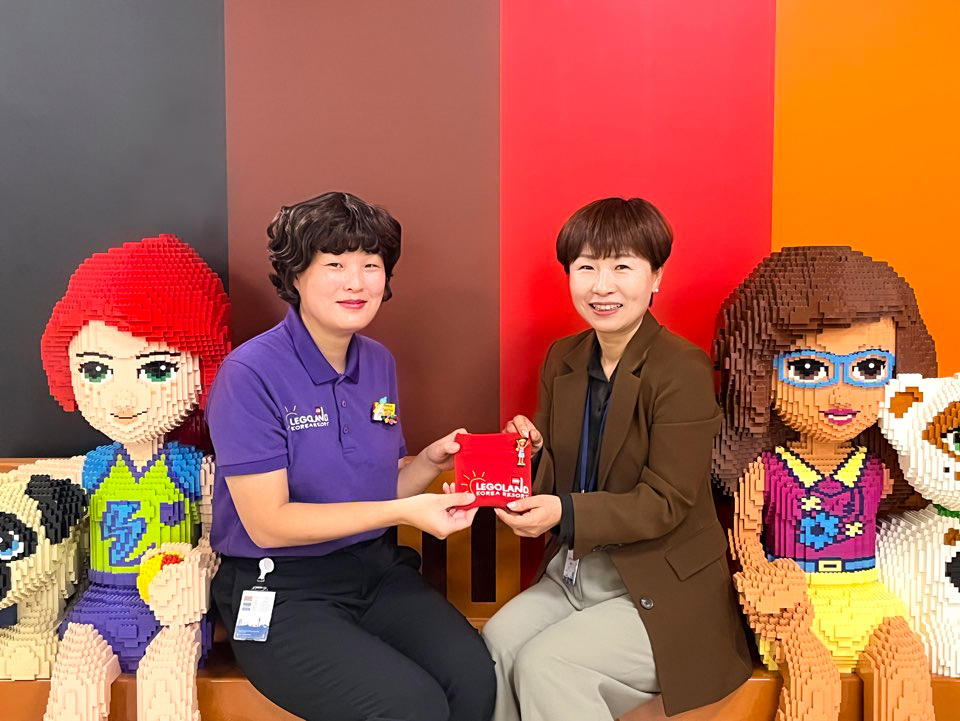 이은희 레고랜드 의상 담당(왼쪽)이 이재경 춘천시 근화동복지센터장에게 폐유니폼으로 제작된 생리대 파우치를 전달하고 있다. 사진=레고랜드 코리아