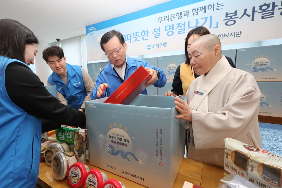 조병규 우리은행장(가운데)와 관계자들이 7일 서울시 종로노인종합복지관에서 먹거리 세트를 포장하고 있다. 사진=우리은행