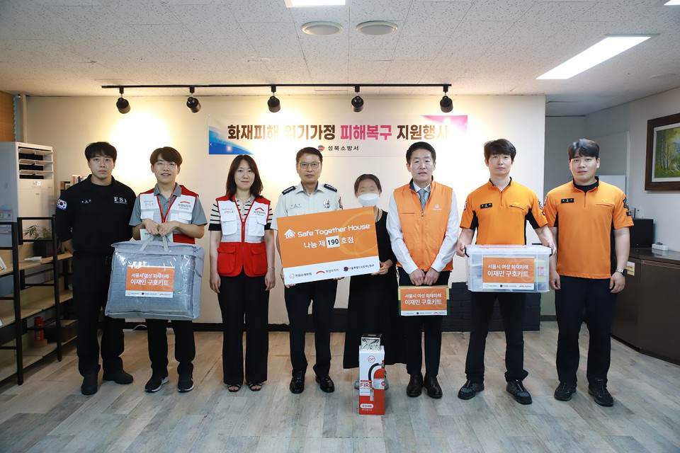 희망브리지와 한화손보가 화재로 생활고를 겪고 있는 여성 가정에 위로금과 구호물품을 전달하고 기념사진을 촬영하고 있다. 사진=희망브리지