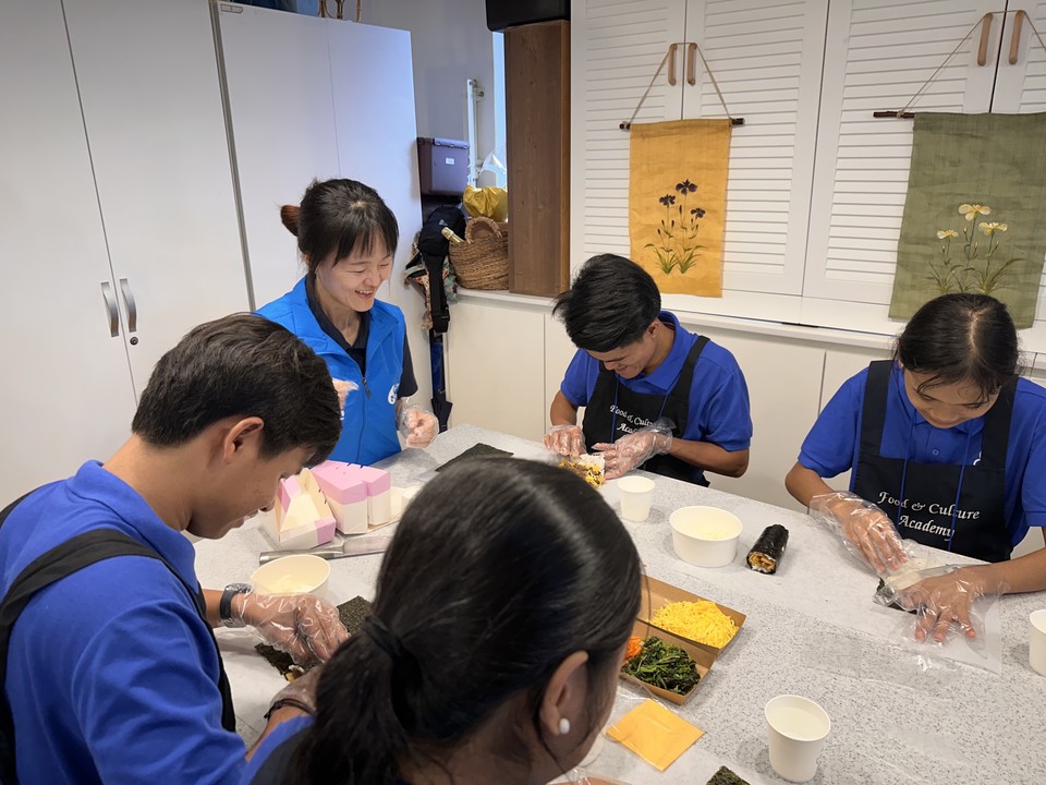 필리핀 앙헬레스 동방아동센터 이스턴 합창단원들이 지난 20일 서울시 중구 배화여자대학교에서 신한금융그룹 임직원들이 준비한 한국 음식 만들기 문화 체험을 하고 있다. 사진=신한금융그룹