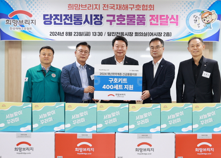 당진시의회 서영훈 의장(왼쪽부터)과  희망브리지 신훈 사무총장, 당진시 오성환 시장, 당진전통시장 정제의 상인회장, 희망브리지 진세근 감사가 기념촬영을 하고 있다. 사진=희망브리지 전국재해구호협회