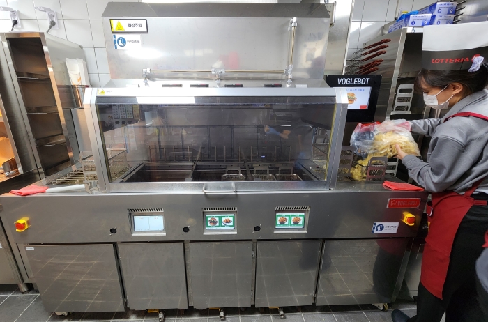 11일 재오픈한 롯데리아 서울대입구역점에 도입한 주방 자동화 후리이어 ‘보글봇’을 활용해 포테이토를 조리 하기 위한 작업을 진행하고 있는 모습. 사진=롯데GRS
