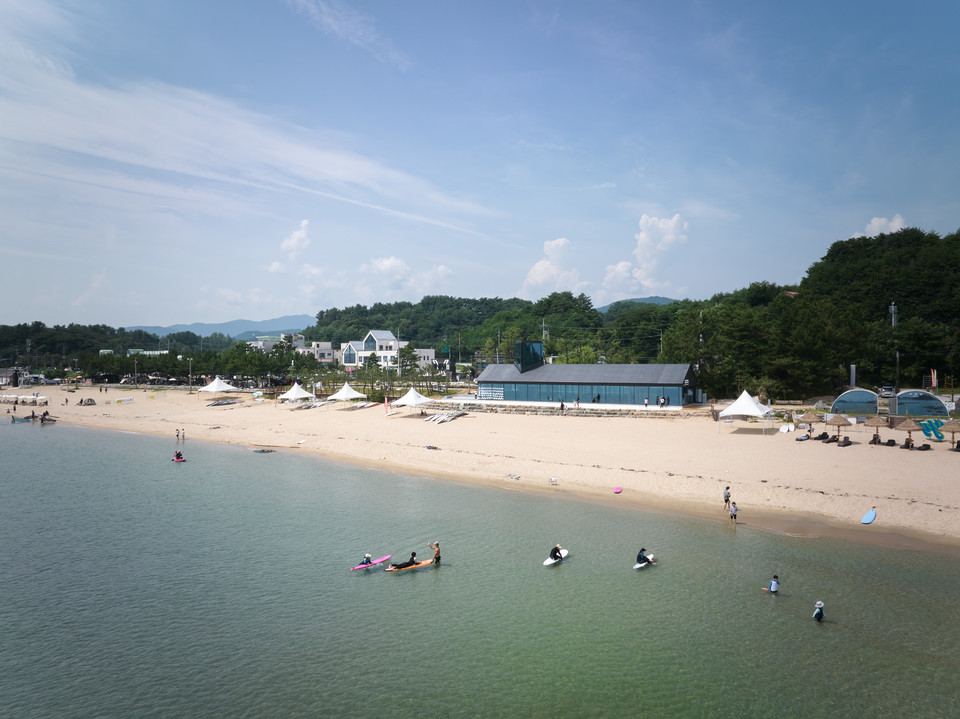 양양 해변에서 서퍼들이 서핑을 즐기고 있다. 사진=김동규 작가