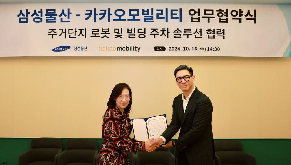 장성욱 카카오모빌리티 미래이동연구소장(오른쪽)과 조혜정 삼성물산 DxP본부장' 주거단지 로봇 및 빌딩 주차 솔루션 협력 업무협약'을 체결하며 기념 촬영을 하고 있다. 사진=캌카오모빌리티