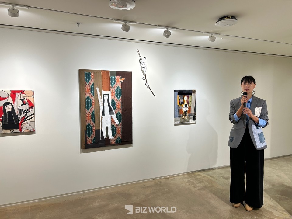 정희기 작가가 '손의 시간'展에서 자신의 작품을 설명하는 모습. 사진 가장 왼쪽 작품이 'I Agree'이다. 사진=김선주 기자