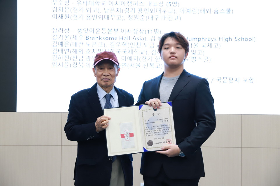 이경재 H2O품앗이운동본부 이사장(왼쪽)과 김한성 학생이 '한국전 참전용사 감사편지 쓰기 공모전' 시상식에서 기념 촬영을 하고 있다. 사진=H2O품앗이운동본부