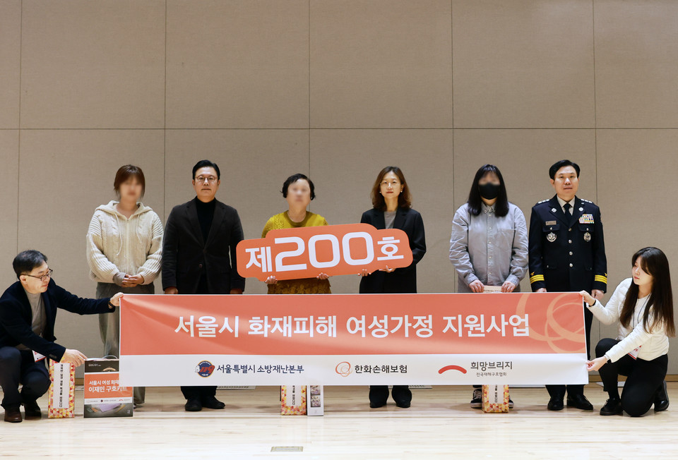 서울 은평구에 위치한 서울특별시소방학교에서 화재피해 위기 여성 가정 200호 지원 전달식 진행 후 기념 촬영을 하고 있다.  사진=희망브리지