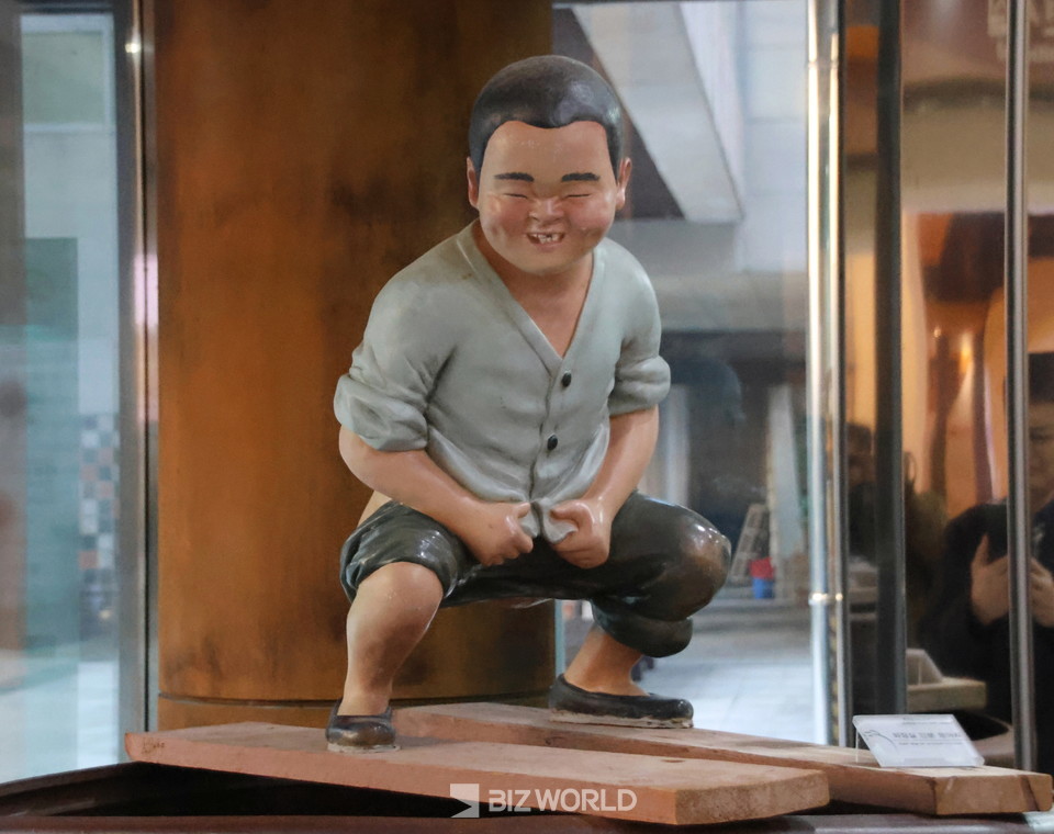 옹기 박물관 입구에  전시된  인분항아리 위에 서 볼일보는 아이. 사진=손진석 기자