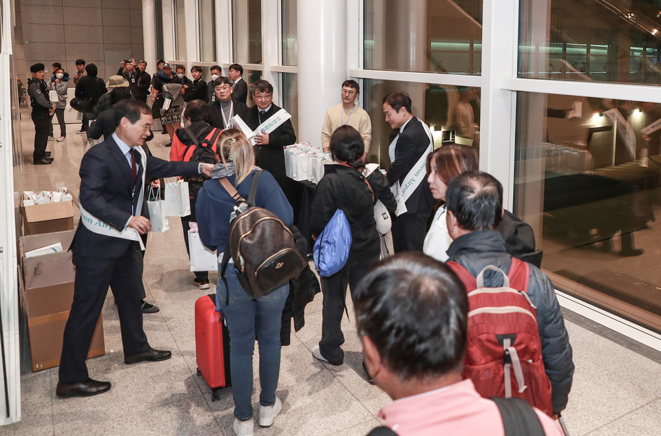 공사 임직원들이 4단계 오픈 첫 도착 항공편에 탑승한 여객들에게 기념품을 전달하고 있다. 사진=인천국제공항공사