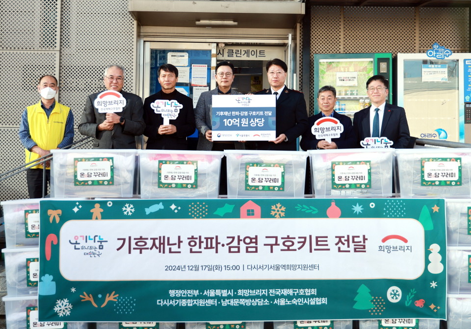 희망브리지 신훈 사무총장이 행정안전부 정종율 재난구호과장, 서울특별시 정충현 복지기획관, 다시서기종합지원센터 여재훈 센터장 등과 전달식에 참석한 관계자들이 기념 촬영을 하고 있다. 사진=희망브리지