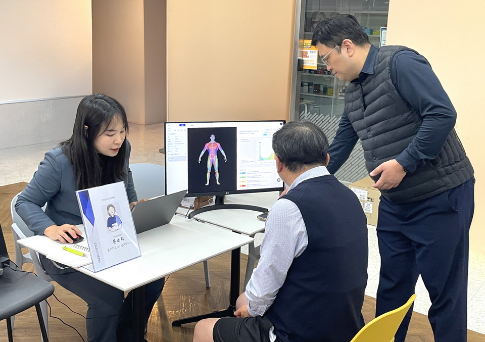 대웅제약 임직원(가운데)이 AI 근감소증 진단기기를 이용해 검사를 받은 후, 근감소증 유병 여부를 확인하고 있다. 사진=대웅제약