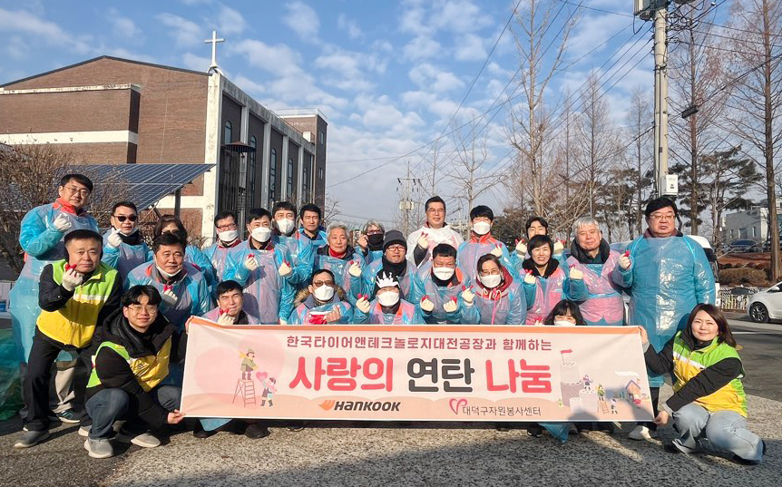 따뜻한 겨울나기 연탄 나눔 봉사활동에 참여한 한국타이어 대전공장 직원들이 기념 사진을 촬영하고 있다. 사진=한국타이어