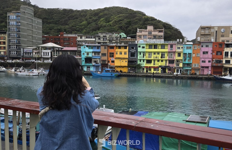 화평도와 이어주는 자그마한 무지개 다리 앞에서 정빈어항의 무지개 마을을 감상하고 있는 관광객. 타이완=손진석 기자