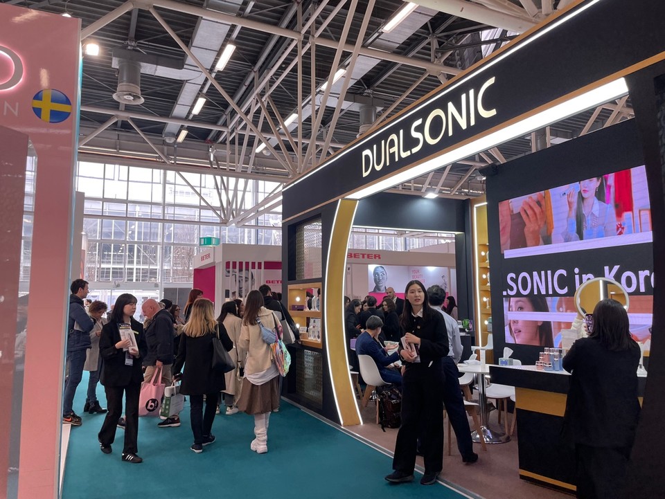 듀얼소닉이 이태리에서 열린 ‘코스모프로프 볼로냐 전시회’에서 듀얼소닉 맥시멈, 프로페셔널 알파, 이펙트, 뷰티루틴 등 뷰티 디바이스부터 이너뷰티, 코스메틱까지 다양한 라인업을 선보였다. 부스 방문객들이 제품을 체험하고 있다. 사진=듀얼소닉