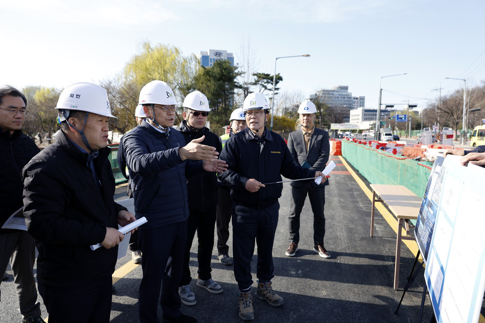 황상하 사장(왼쪽 세 번째) 등 현장 점검단이 통행 예정인 임시 가설 교량 위에서 공사 진행 사항 등을 보고 받고 있다. 사진=SH공사
