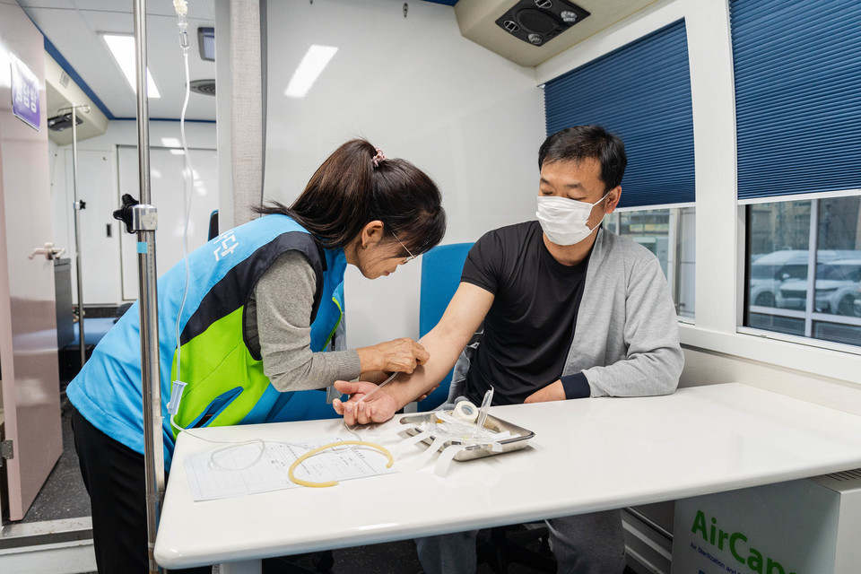 희망브리지 진료 차량 내에서 의료진이 이재민에게 주사를 놓고 있다. 사진=희망브리지