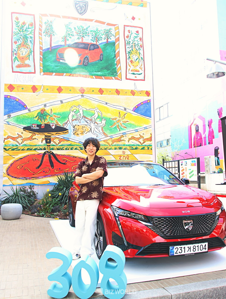 아티스트 헤르시(HERNC)가 푸조 308 스마트 하이브리드 앞에서 포즈를 취하고 있다. 사진=손진석 기자