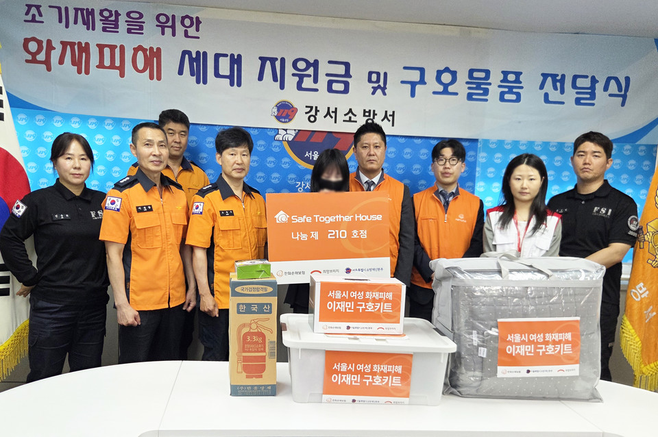 희망브리지와 한화손해보험 관계자가 서울 강서소방서에서 화재 피해를 입은 여성 가정에 위로금과 구호키트를 전달하고 기념촬영을 하고 있다. 사진=희망브리지