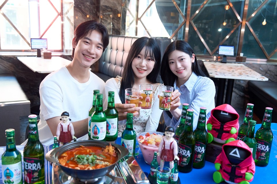 방학 시즌을 맞은 대학생들이 ‘테라·참이슬 오징어 게임 에디션’ 제품과 굿즈를 함께 즐기고 있다. 사진=하이트진로