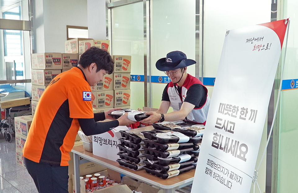 희망브리지 직원이 집중호우 대응에 나선 소방공무원에게 도시락을 전달하고 있다. 사진=희망브리지