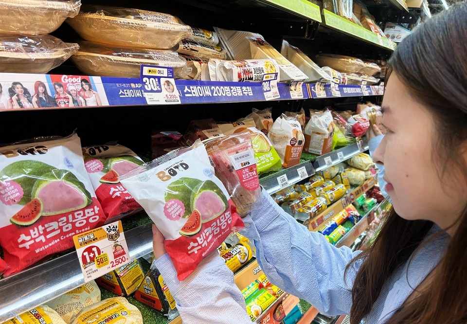 한 소비자가 이마트24 매장에서 BOTD 수박 콘셉트 상품을 구매하고 있다. 사진=이마트24