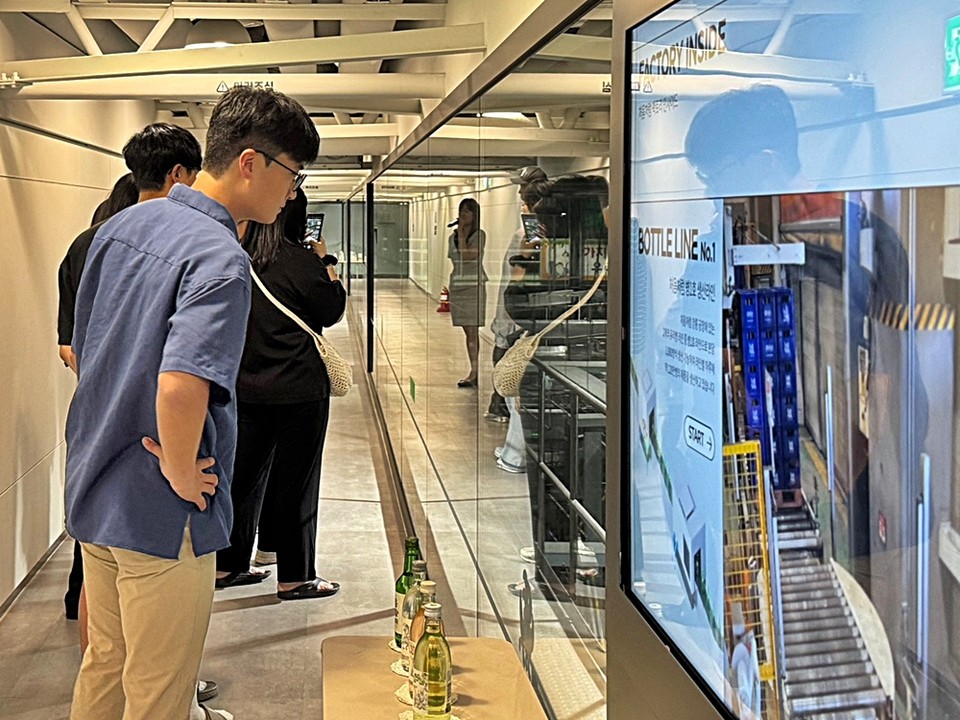 방문객들이 강릉공장에 위치한 ‘처음처럼 브랜드 체험관’에서 공정 관람을 하고 있다. 사진=롯데칠성음료