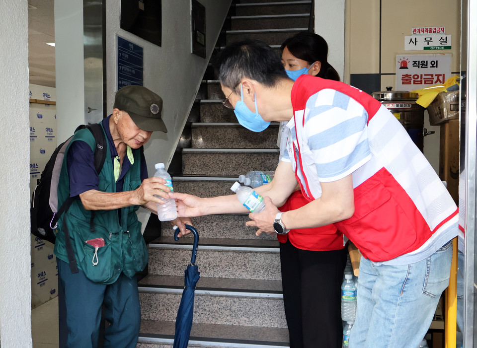 희망브리지 직원이 서울역 인근 노숙인 무료급식소 따스한 채움터에서 생수를 나눠주고있다. 사진=희망브리지