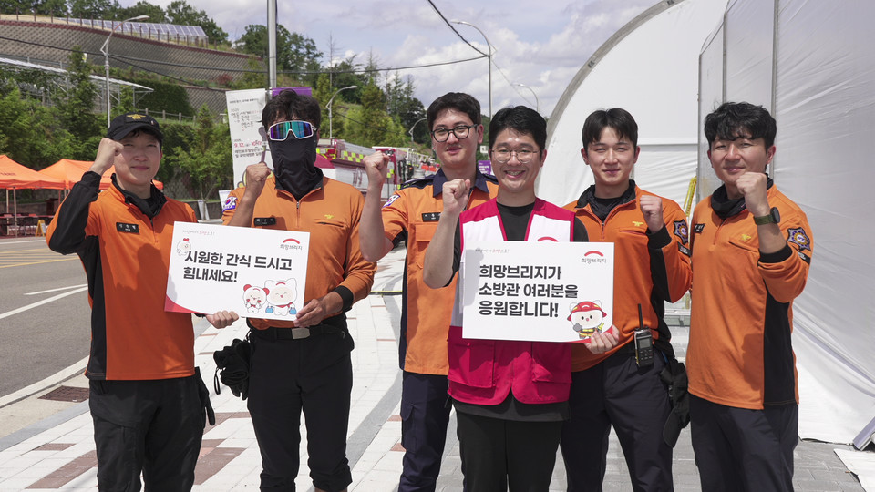 전국재해구호협회 직원이 긴급구호종합훈련에 참여한 소방대원들에게 간식을 지원한 뒤 기념촬영을 하고 있다. 사진=전국재해구호협회