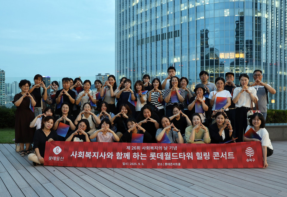 참가자들이 ‘롯데월드타워 123층’을 수어로 표현하며 기념사진을 촬영하고 있다. 사진=롯데물산