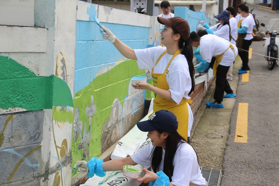 오스템임플란트 임직원들이 지난 18일 서울 강서구에 위치한 상사마을 경로당에서 벽화 그리기 봉사를 전개하고 있다. 사진=오스템임플란트
