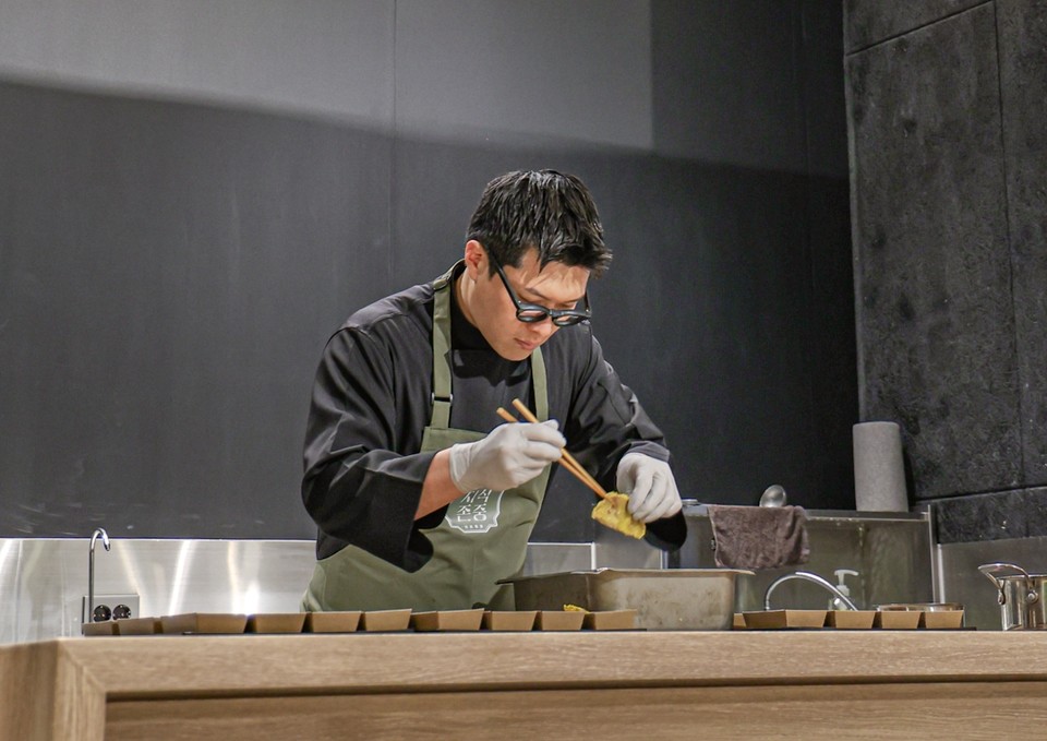 대상그룹이 ‘지식존중 프로젝트’의 일환으로 경북 영양군의 청정 자연과 특산물을 알리기 위해 지난 12일부터 21일까지 열흘 동안 연 ‘핀란드 영양분식’ 팝업이 총 8000여 명의 방문객을 불러 모으며 성황리에 마무리됐다고 밝혔다. 마마리마켓의 송하슬람 셰프가 대상그룹 _핀란드 영양분식 팝업 현장에서 자작자작 숲속분식_메뉴를 선보이고 있다. 사진=대상그룹