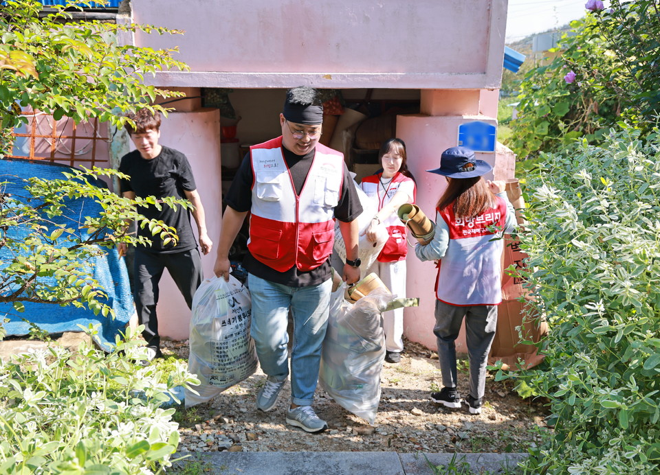 폐기물을 옮기는 희망브리지 직원. 사진=희망브리지
