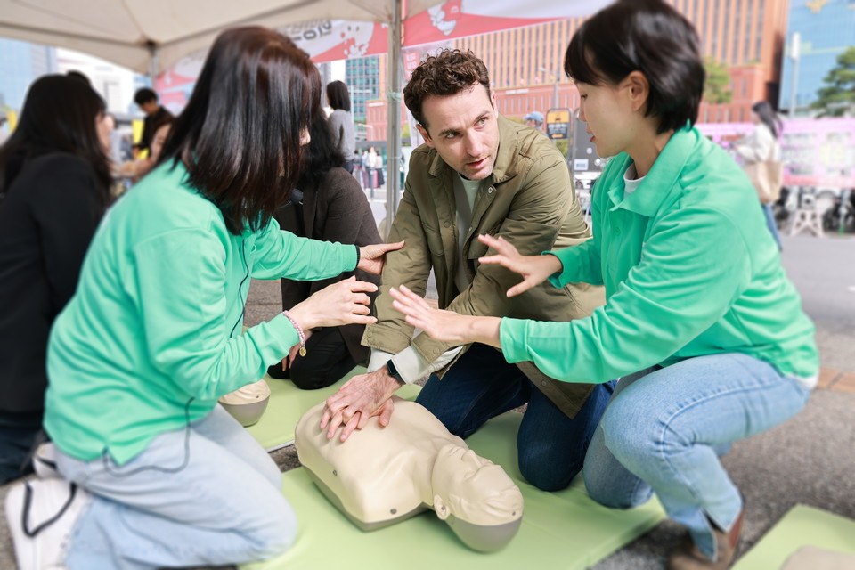 외국인 참여자가 희망브리지 관계자의 안내에 따라 심폐소생술을 배우고 있다. 사진=희망브리지