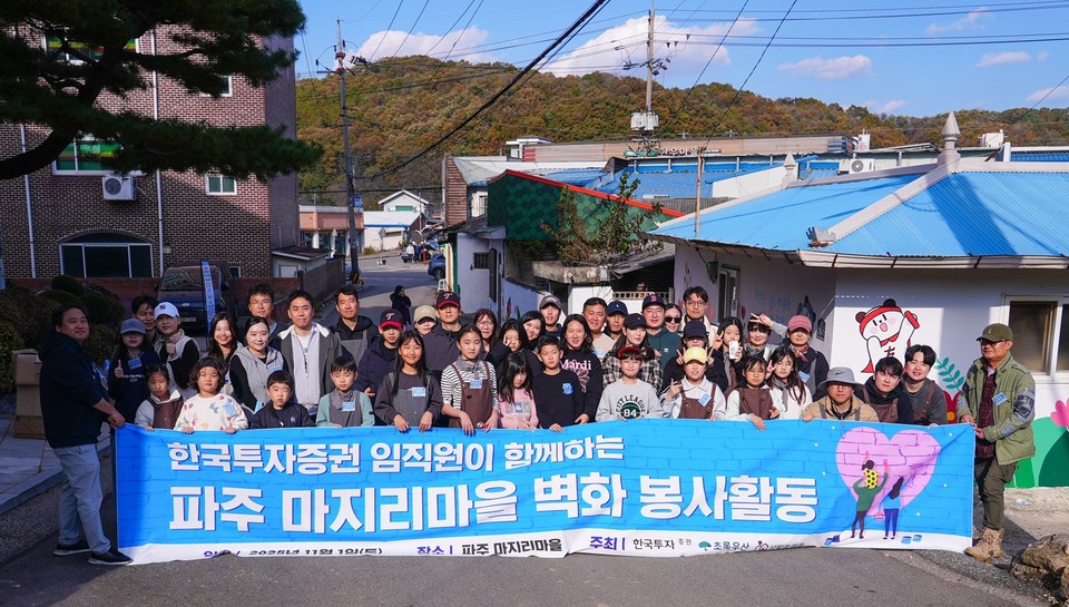 지난 1일 한국투자증권 임직원과 가족들이 경기도 파주에 있는 마지리 마을에서 벽화그리기 봉사활동을 하고 나서 기념 사진을 촬영하고 있다. 사진=한국투자증권
