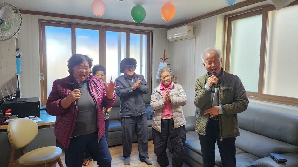 스마트 경로당에서 어르신들이 화상 시스템을 활용한 실시간 노래 교실에 참여하며 즐거운 시간을 보내고 있다. 사진=나우비긴