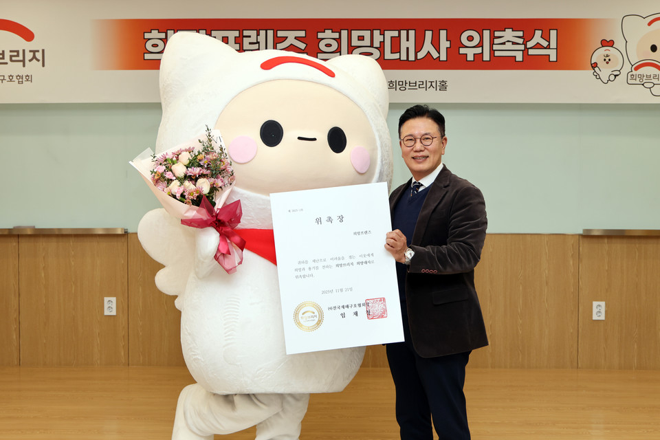 신훈 희망브리지 사무총장이 공식 캐릭터 희망프렌즈를 희망대사로 위촉하고 기념사진 촬영을 하고있다. 사진=희망브리지