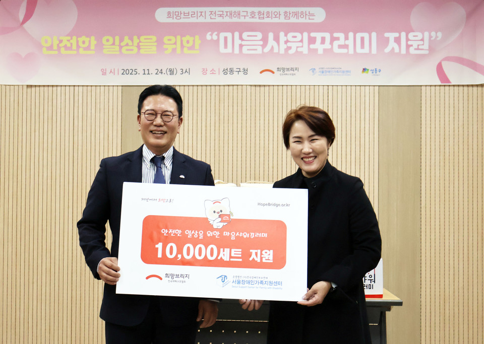 희망브리지 신훈 사무총장(왼쪽)과 서울장애인가족지원세터 김남연 광역센터장이 재난 취약계층을 위한 마음샤워꾸러미 1만세트 전달식 기념촬영을 하고 있다. 사진=희망브리지